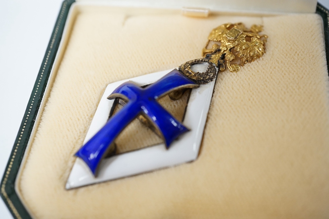 A Russian award issued between 1899-1908 to students who failed to graduate from medical school, known as the Patrikeev-Boynovich badge, enamel on silver with a gilt double eagle. Condition - fair to good, minor damage t